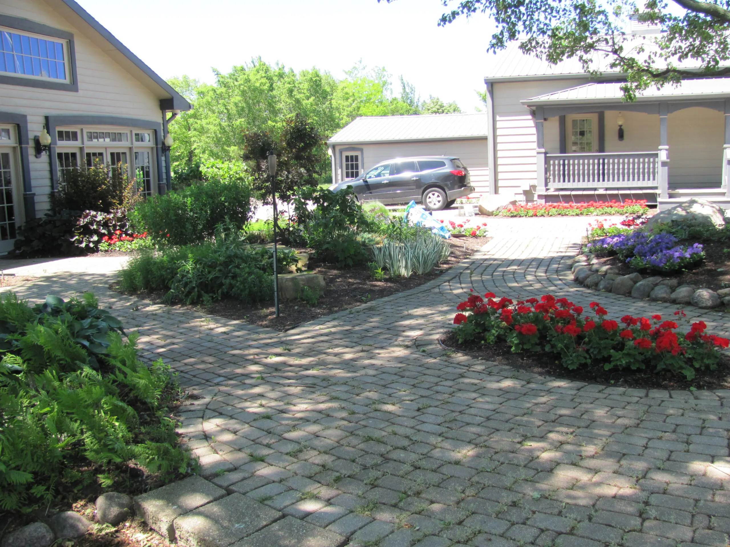 A brick walkway with flowers in the middle of it.