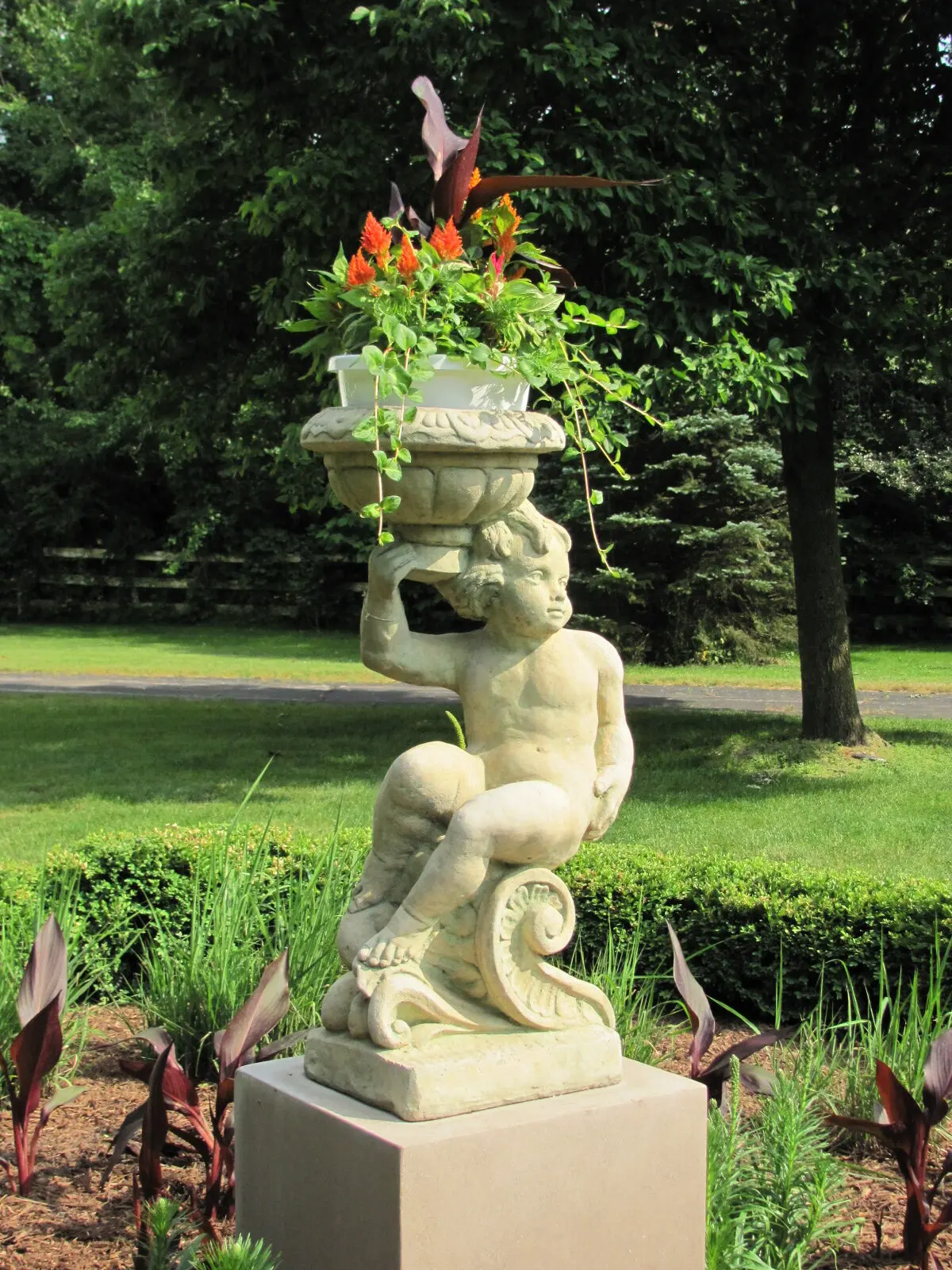A statue of a man holding a plant in his hands.