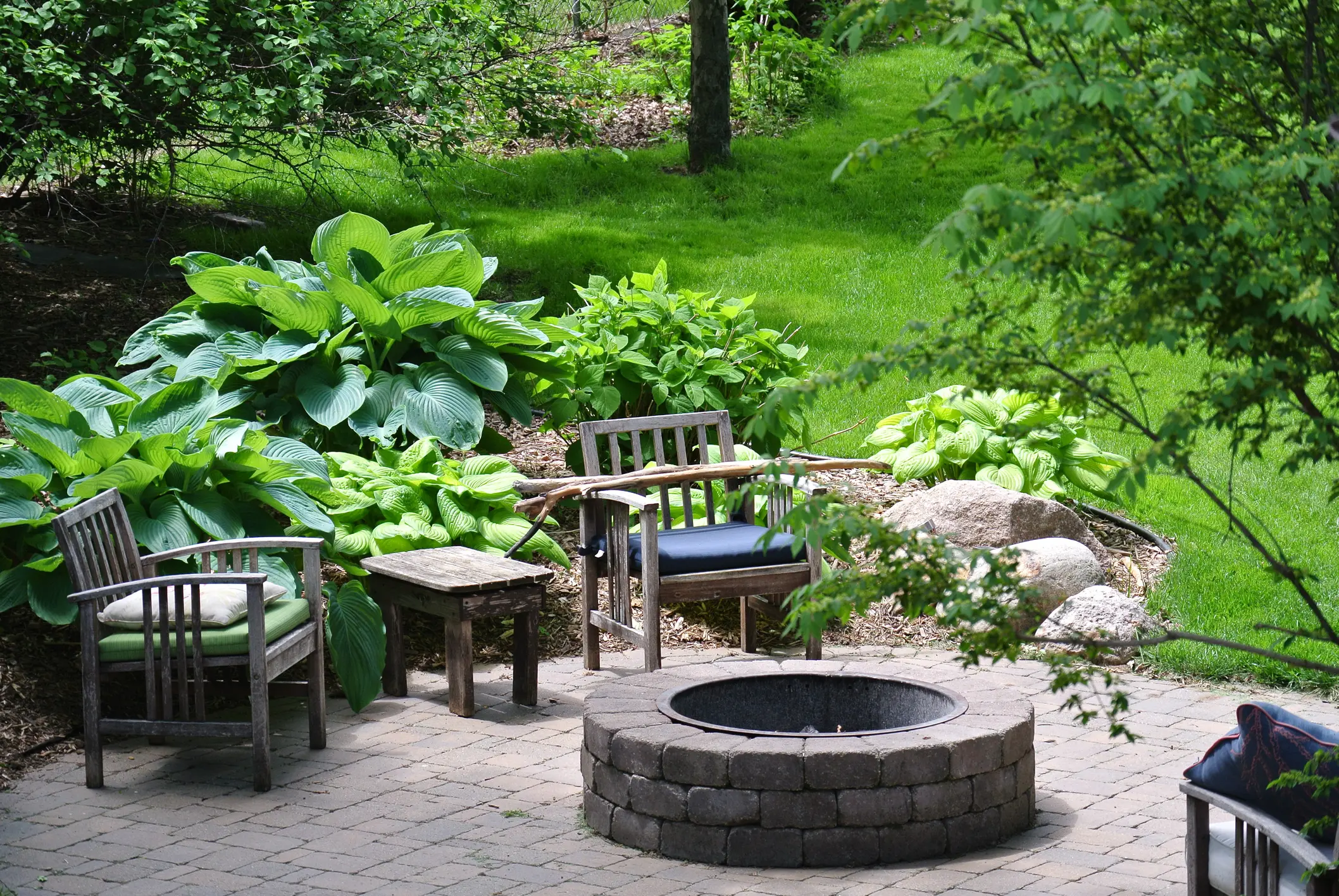 Backyard Firepit A fire pit in the middle of an outdoor patio.